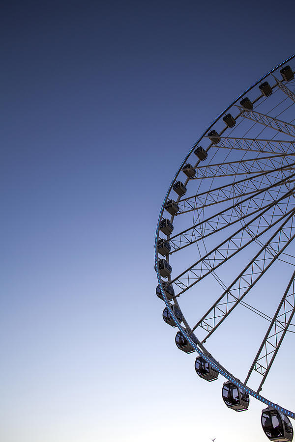 Low angle view of ferris wheel against blue sky Photograph by Adam Hester