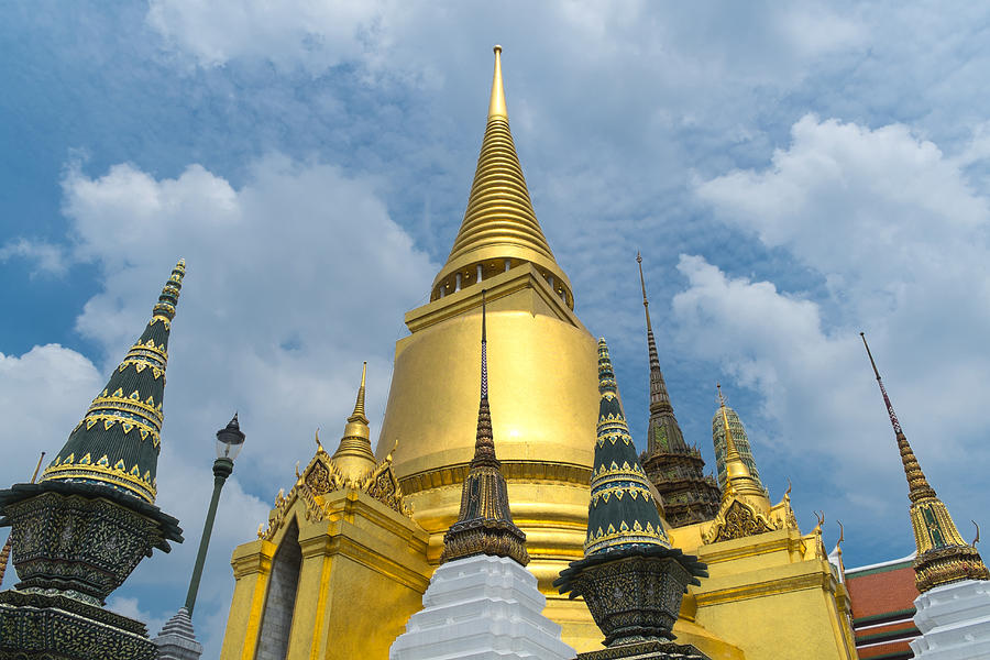 Low angle view of golden ornate temple spires, Bangkok, Thailand Photograph by John D. Buffington