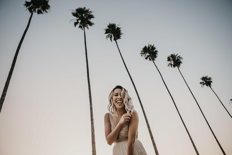 Low angle view of happy bride under palm trees Photograph by Westend61