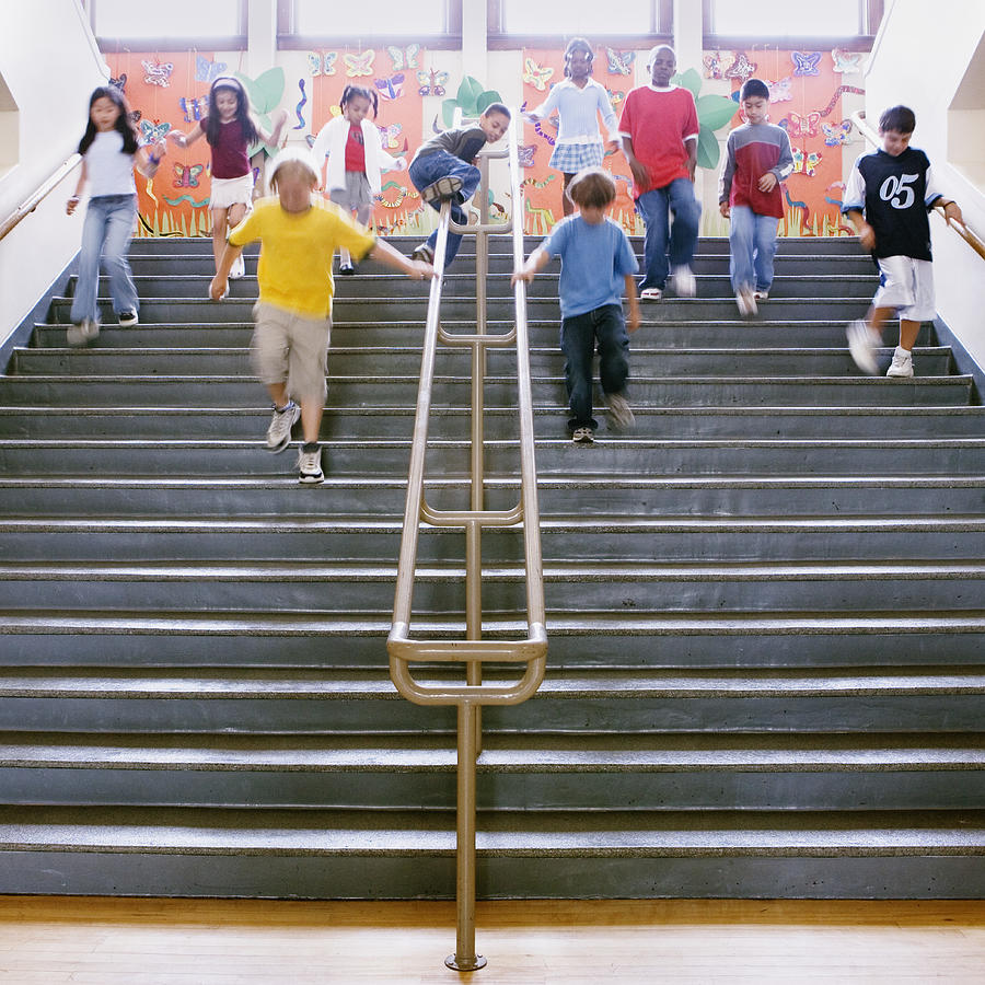 Low angle view of school children running down the stairs Photograph by Andersen Ross Photography Inc