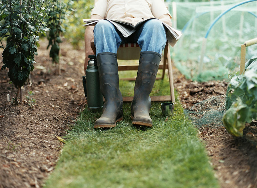Low Section of a Man in a Garden Sitting in a Deck Chair With a Newspaper on his Lap Photograph by Iain Crockart