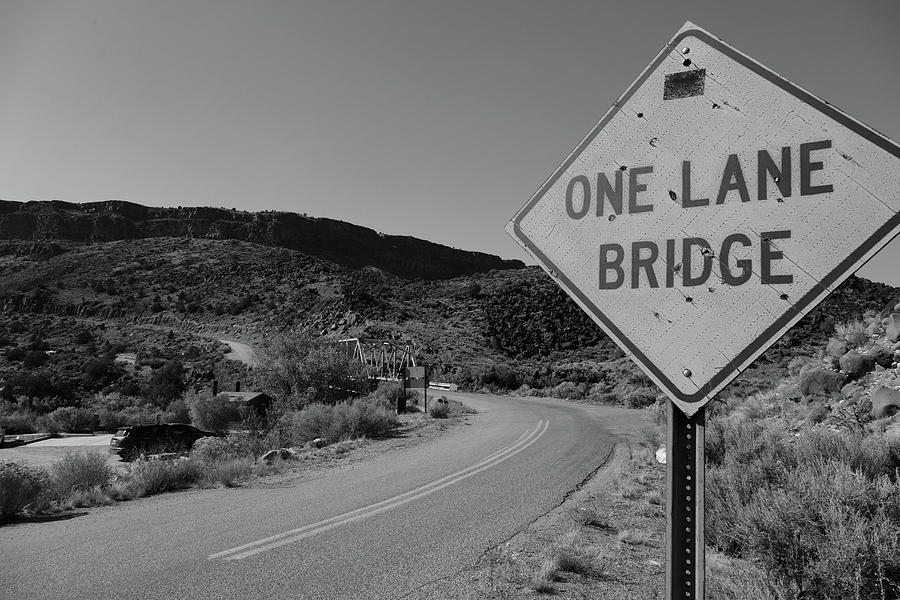 Lower Taos Canyon in New Mexico One Lane Bridge Sign in black and white Photograph by Eldon McGraw