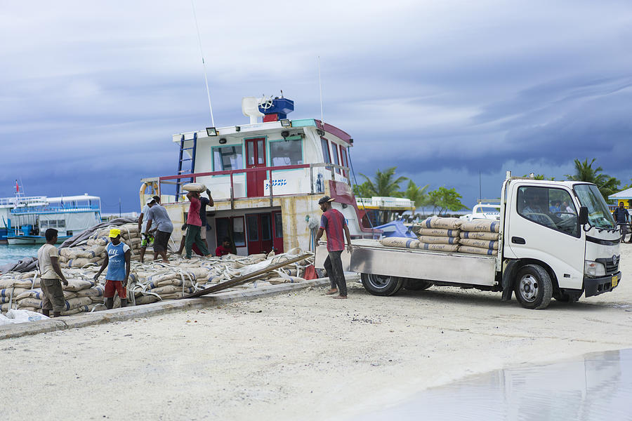 Maafushi Island port, unloading the construction material on small truck in April, Maldives Photograph by DavorLovincic