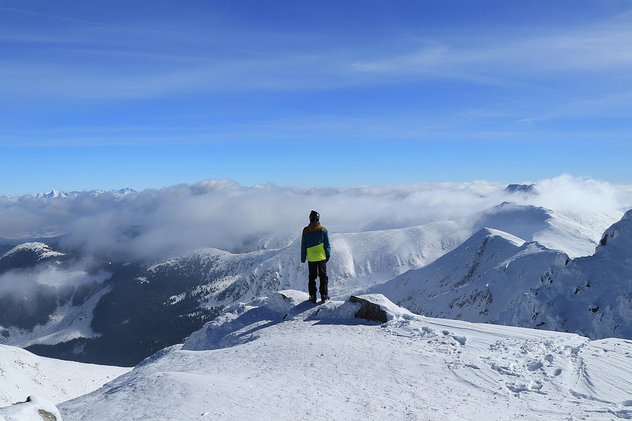 Magical panorama on peak of Chopok with view to High Tatras and Dumbier. Young skier enjoy freedom and paradise looks. Man in colorful ski clothes stand on the edge of mountain and watchs landscape Photograph by Vaclav Sonnek
