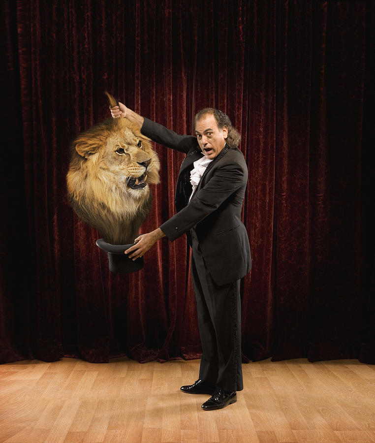 Magician pulling a lion out of a hat Photograph by John M Lund Photography Inc