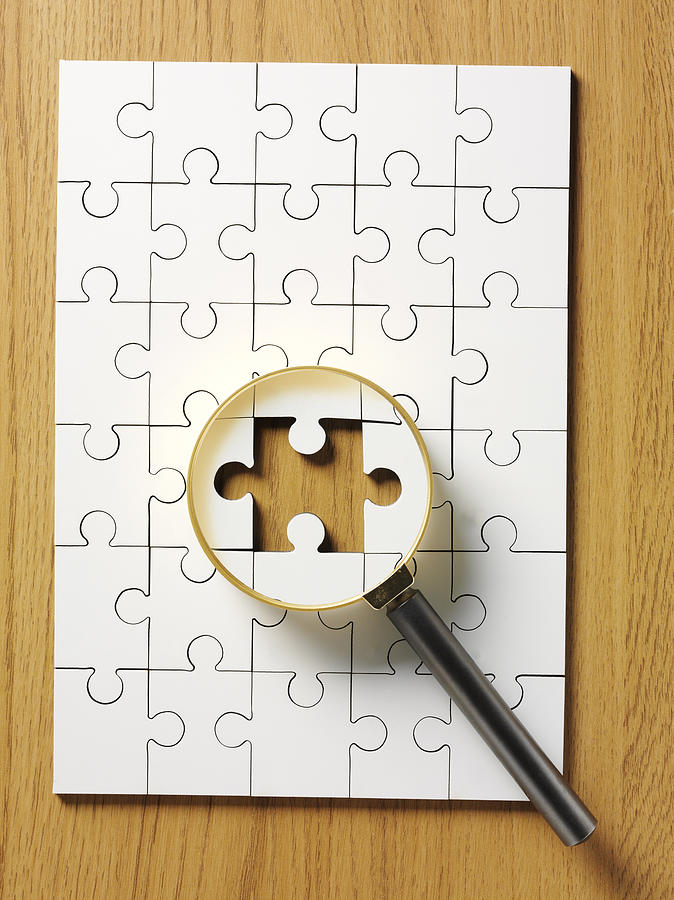 Magnifying Glass on a Jigsaw Puzzle Photograph by Wragg