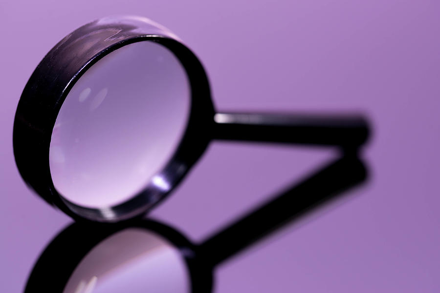 Sign Photograph - Magnifying glass on shiny  light magenta surface  by Benedek Alpar