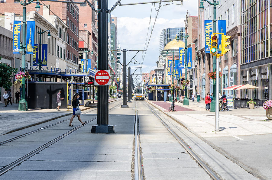 Main street of downtown Buffalo with cable car bus coming during summer day Photograph by Marc Dufresne
