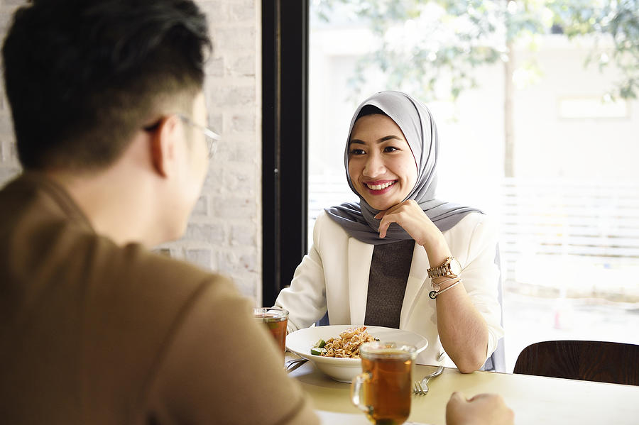 Malaysian man and woman having lunch in a restaurant Photograph by Carlina Teteris