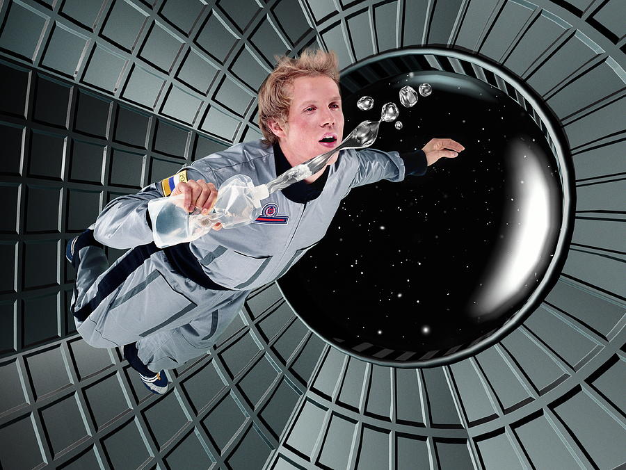 Male astronaut floating in space station (Digital Composite) Photograph by John Lamb