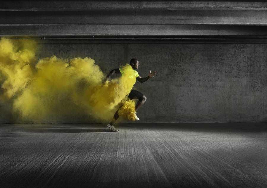 Male athlete running through smoke Photograph by Henrik Sorensen