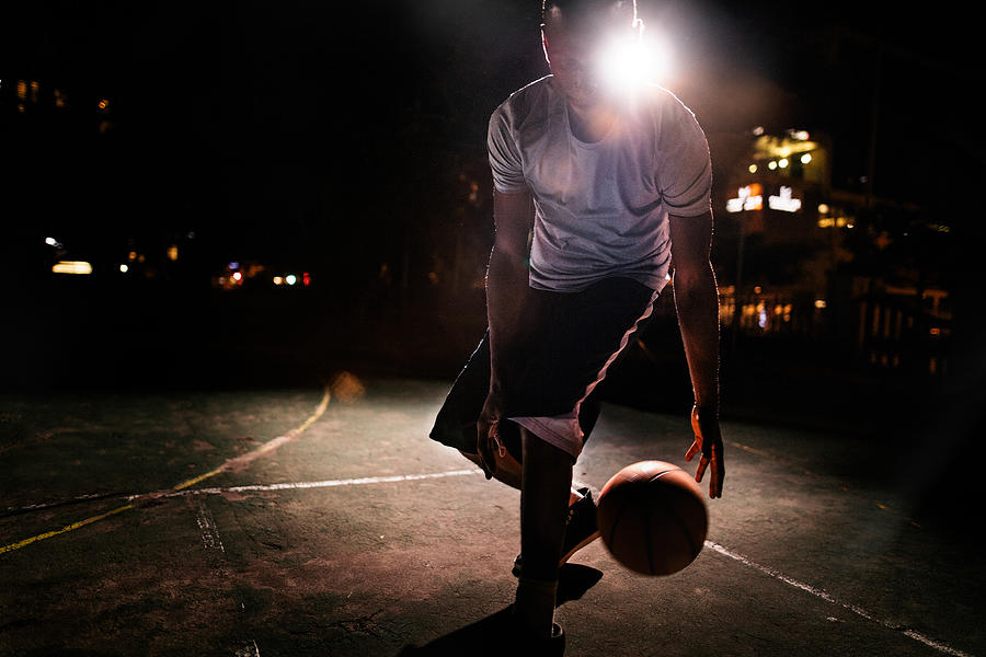 Male Basketball Player Dribbling Ball on Court in Evening Photograph by Wundervisuals