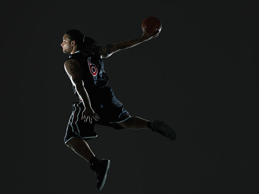 Male basketball player preparing to dunk ball Photograph by Thomas Barwick