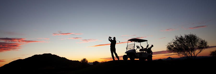 Male Caucasian Golfer Swinging A Golf Club with Cart Photograph by ImagineGolf