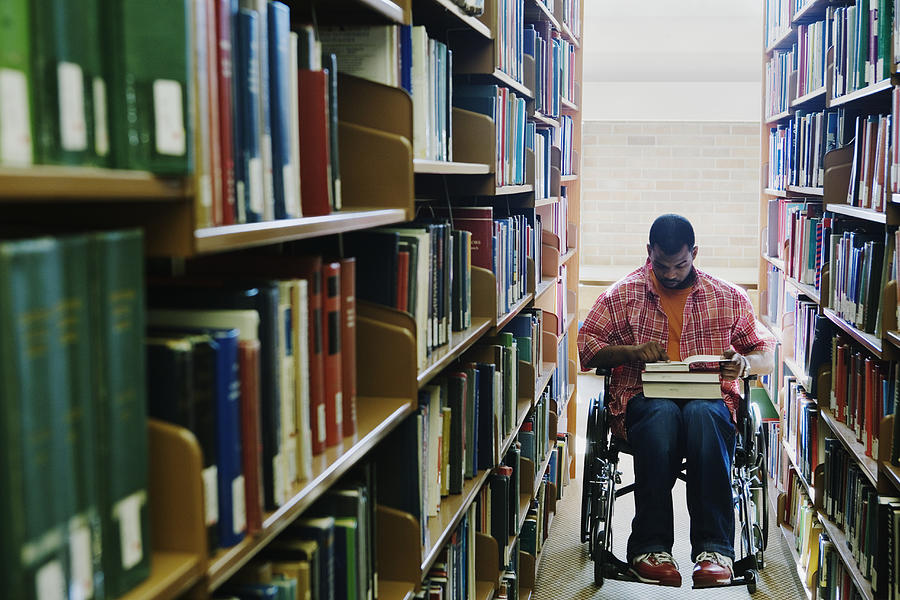 Male college student in wheelchair at library Photograph by Andersen Ross Photography Inc