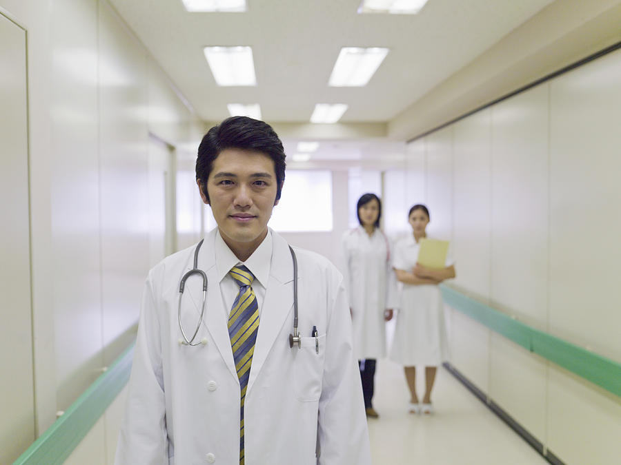 Male doctor in hospital corridor, portrait Photograph by Michael H
