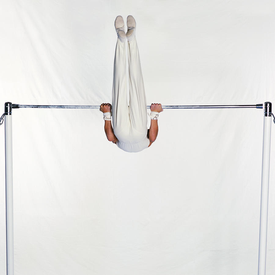 Male gymnast swinging on horizontal bar. Photograph by Dominique Douieb