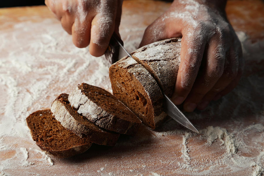 Male hands slicing fresh bread Photograph by 5second