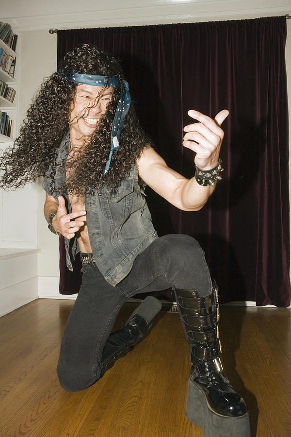 Male heavy metal musician playing air guitar Photograph by Sean Murphy