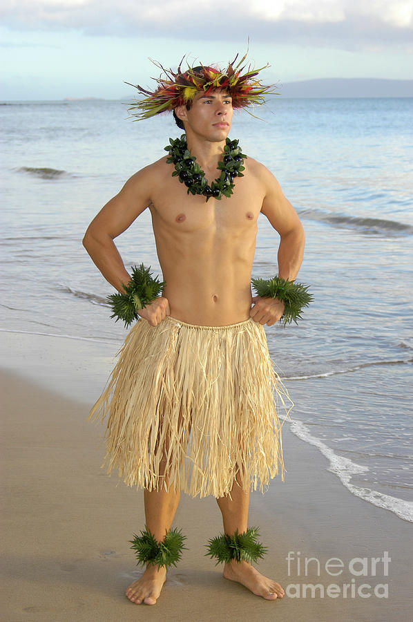 Male hula dancer poses with hand on hips at sunset by the beach. Photograph by Gunther Allen