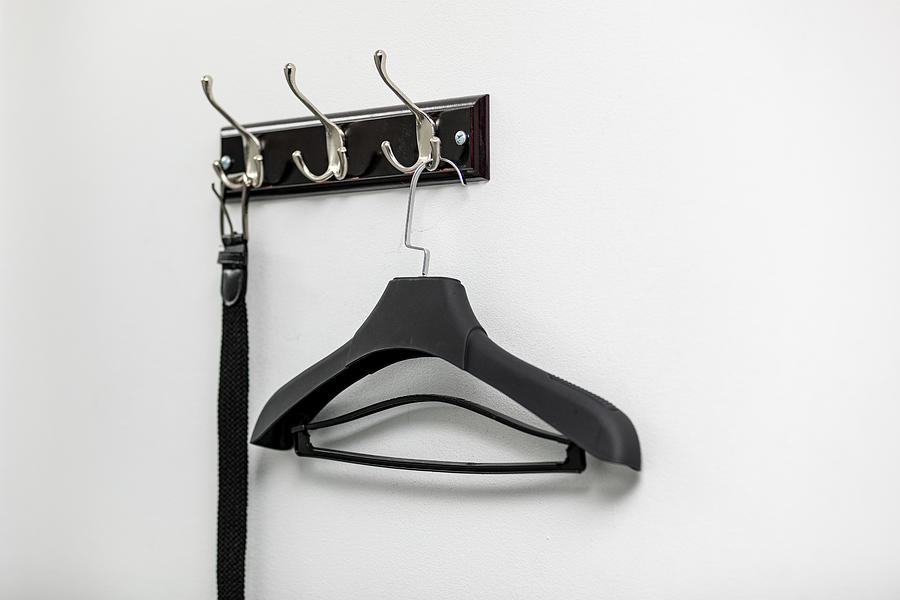 Male leather belt on hanger on hooks. Photograph by Shcherbak Volodymyr