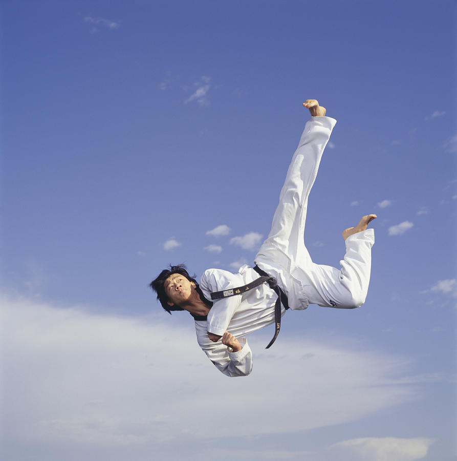 Male martial artist, mid-air, low angle view Photograph by Ryan McVay