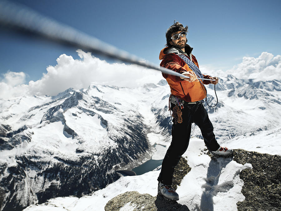 Male mountain climber pulling rope taut, portrait Photograph by David Trood