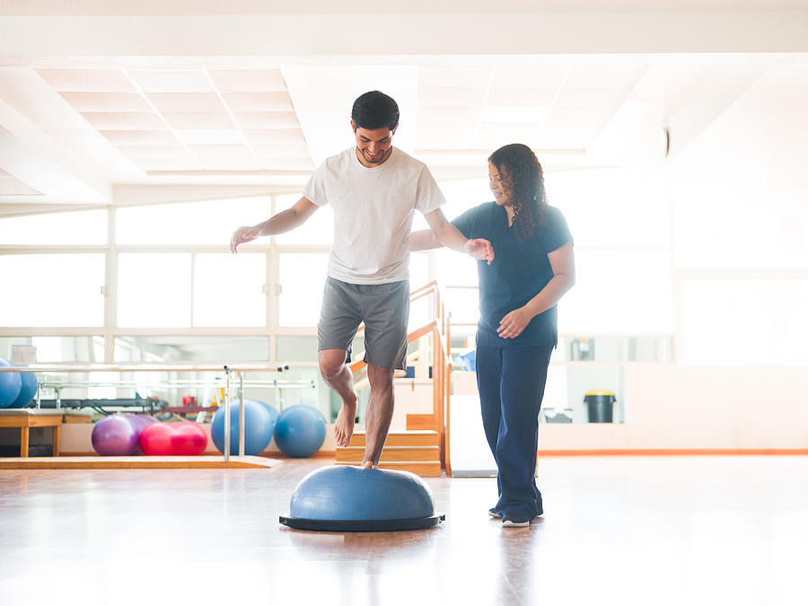 Male physical rehab patient standing on bosu ball Photograph by Aldomurillo