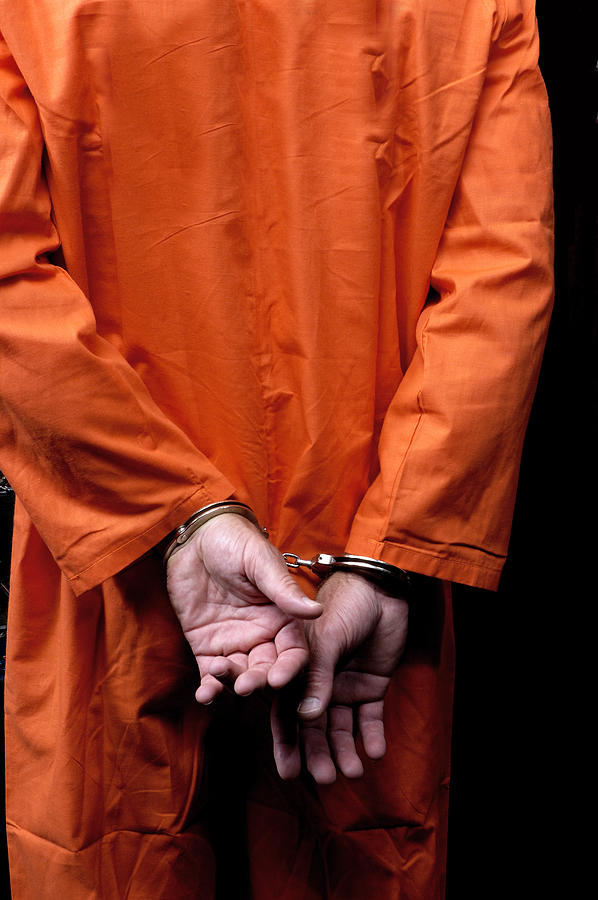 Male prisoner in orange suit his arms handcuffed behind back Photograph by ImagesbyTrista