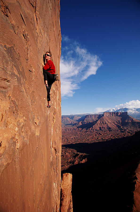 Male rock climber on sheer cliff face Photograph by Tyler Stableford