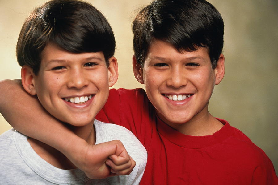 Male twins (10-12) smiling, portrait Photograph by Paul Avis