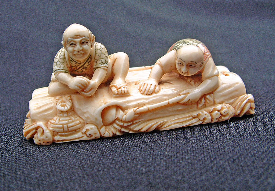 Netsuke Sculpture - Mammoth tusk ivory netsuke featuring 2 men riding on a logs raft.  by Contemporary netsuke artist