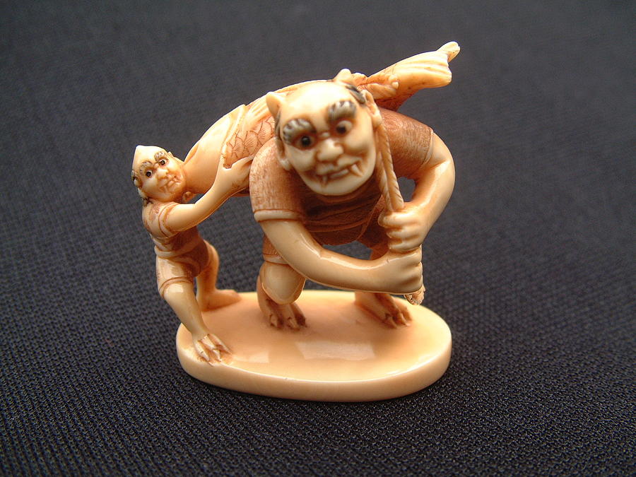 Fish Sculpture - Mammoth tusk ivory netsuke featuring an oni carrying a giant fish by Contemporary netsuke carver