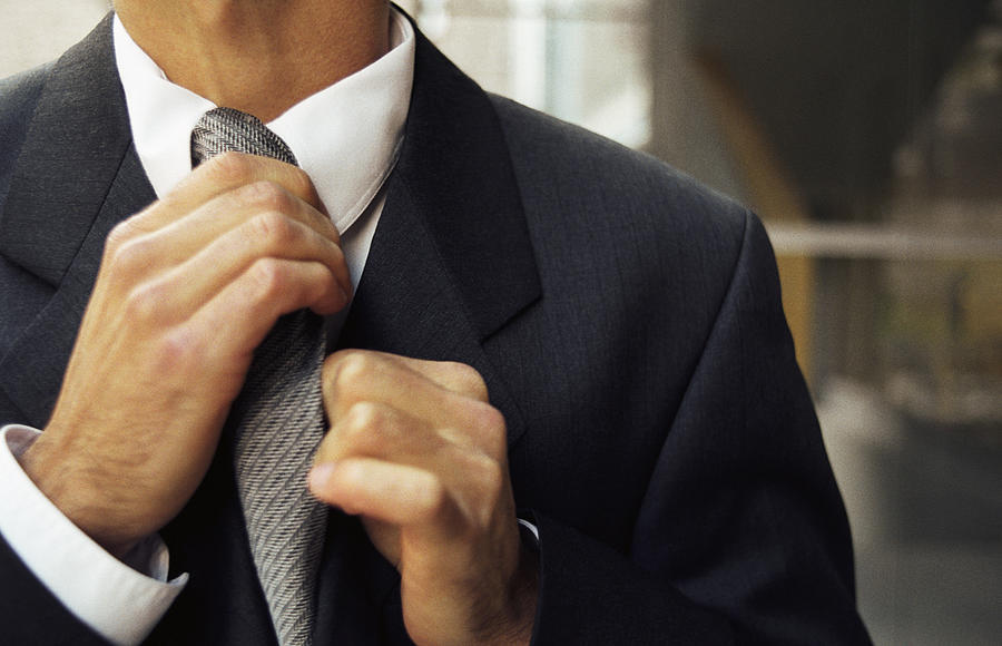 Man adjusting tie, cropped Photograph by PhotoAlto/Katarina Sundelin