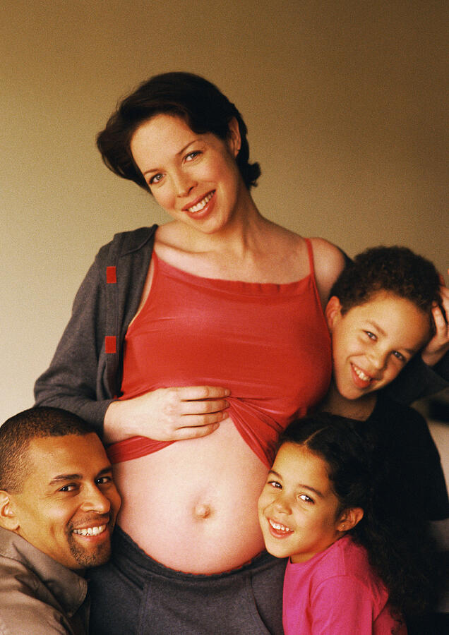 Man and children around pregnant woman, portrait Photograph by John Dowland