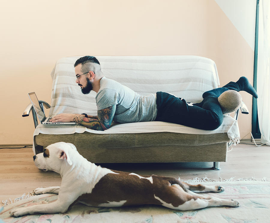 Man and his best friend dog at home. Photograph by Vgajic