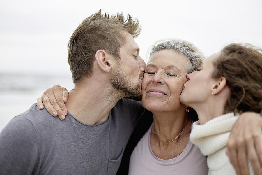 Man and woman kissing senior woman Photograph by Oliver Rossi