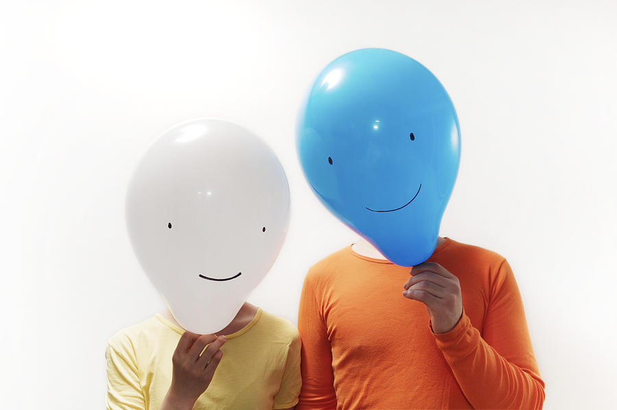 Man and woman with faces obscured by faced balloons Photograph by Jae Rew
