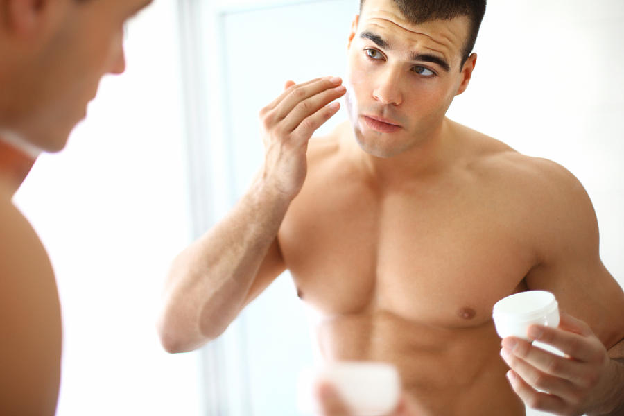 Man applying moisturizer. Photograph by Gilaxia