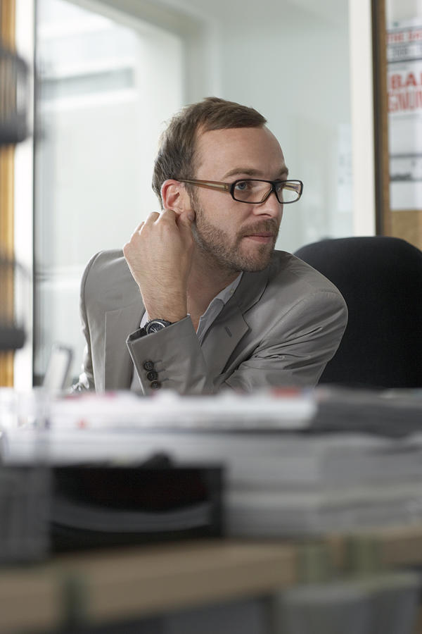 Man At Desk Listens Photograph by Michael Blann