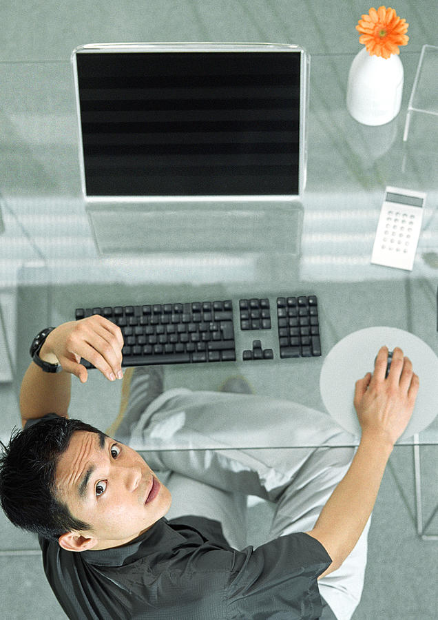 Man at desk with futuristic devices, high angle view, portrait Photograph by Coco Marlet