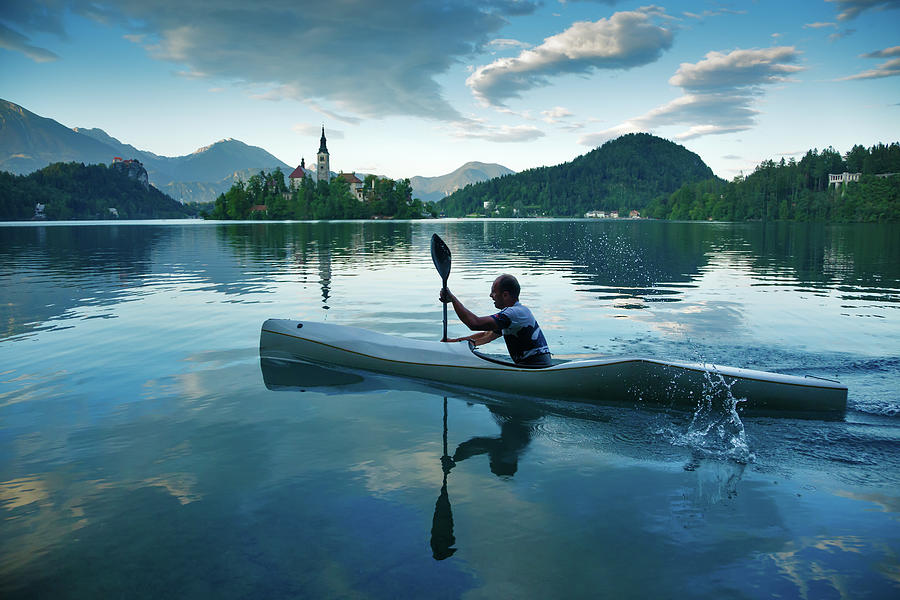 Man canoeing on Lake Bled Photograph by Ian Middleton