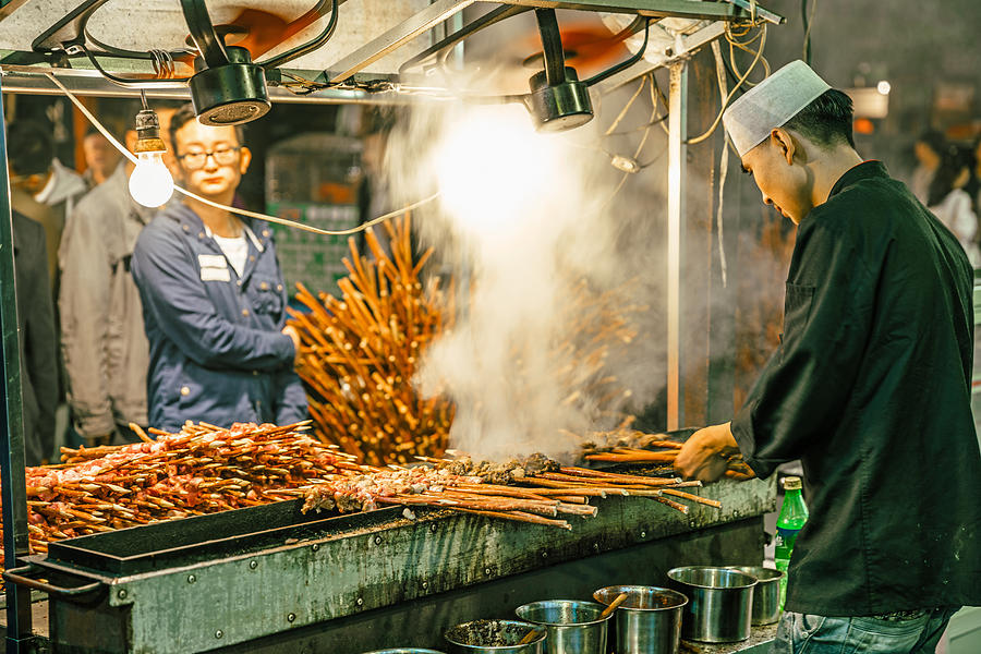 man cooking meat, muslim street market in Xian, China Photograph by Nikada