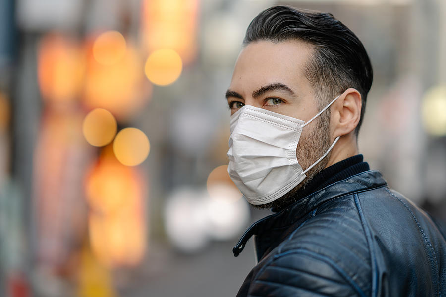 Man covering his face with pollution mask for protection from viruses Photograph by Recep-bg