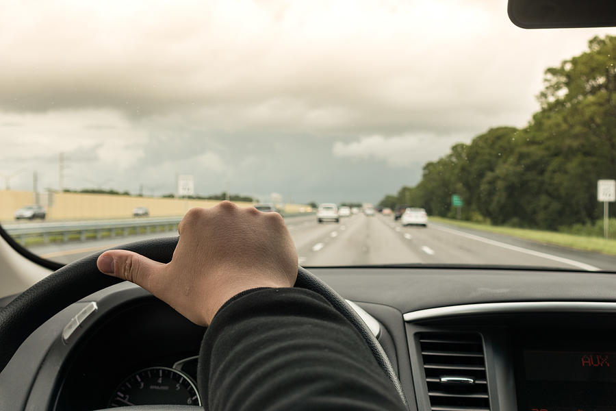 Man driving car on highway, Florida, USA, close up of hand and steering wheel Photograph by Jonny Maxfield