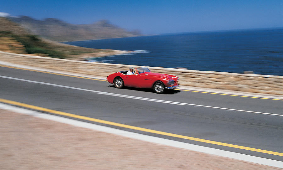 Man Driving Red Sports Car Along Coastal Road Photograph by Flying Colours Ltd