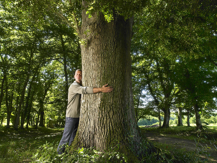Man embracing a tree trunk. Photograph by Ghislain & Marie David de Lossy