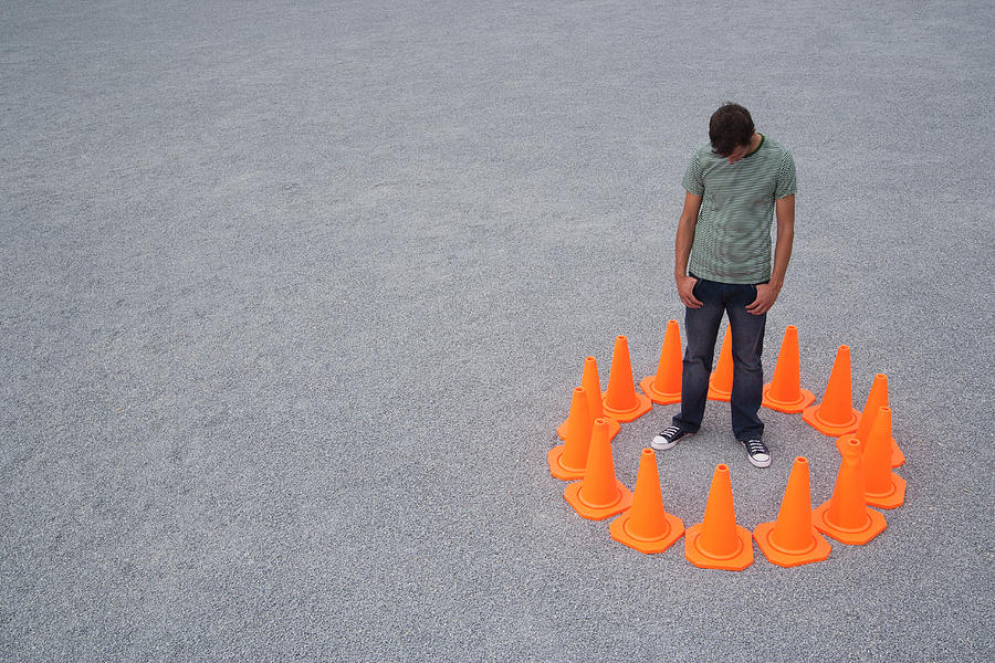 Man encircled by safety cones Photograph by Martin Barraud