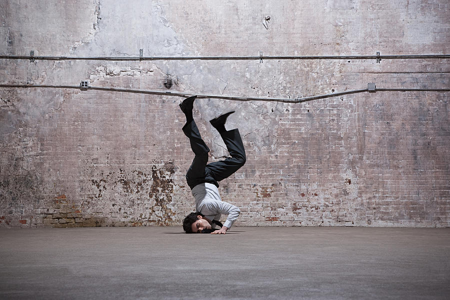 Man falling on head in warehouse Photograph by Image Source