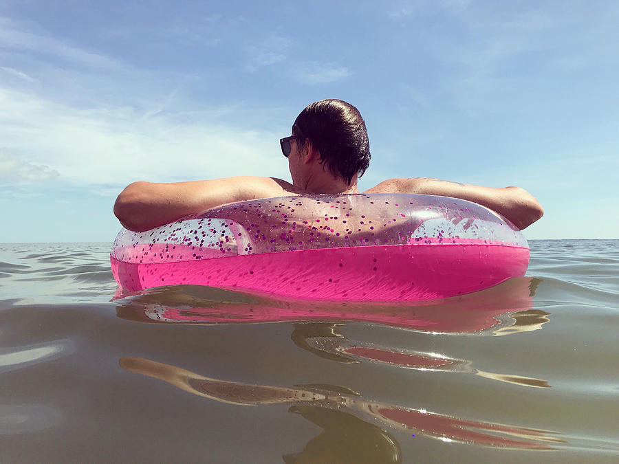 Man Floating in a Pink Inner Tube in the Ocean Photograph by Cyndi Monaghan